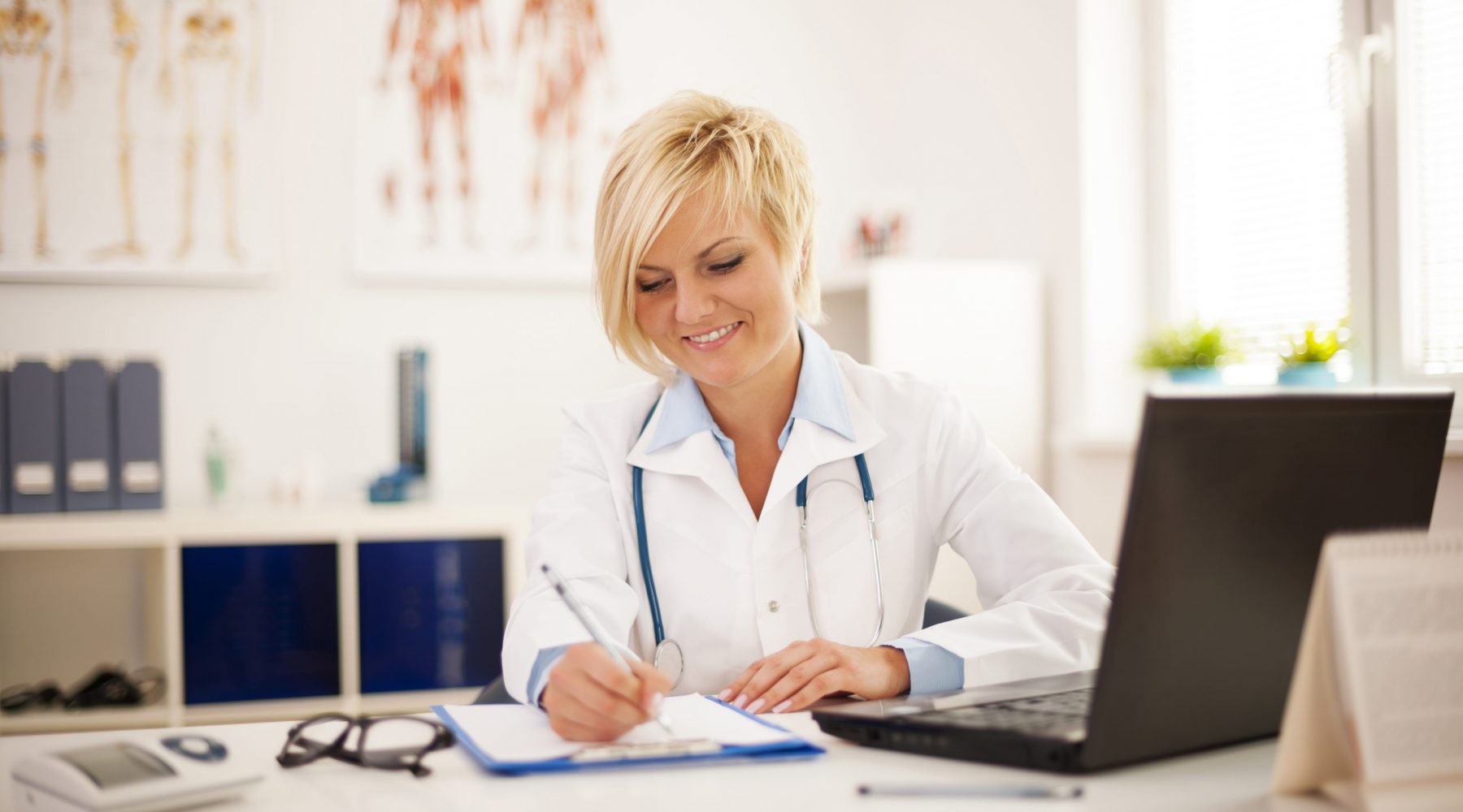 Beautiful young female doctor working at her office